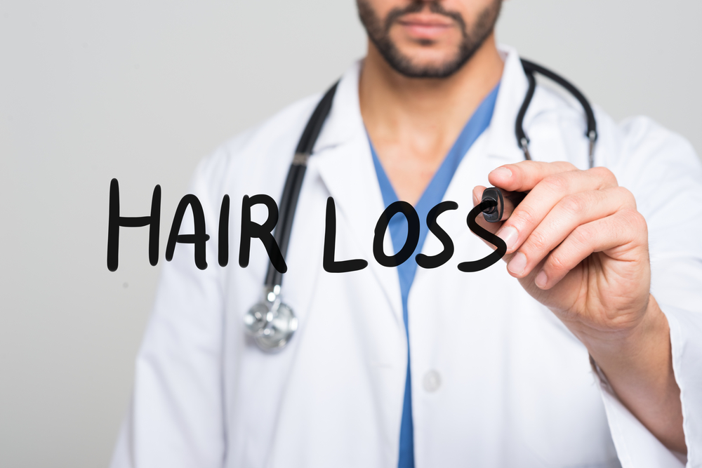 unidentified doctor writing hair loss on air