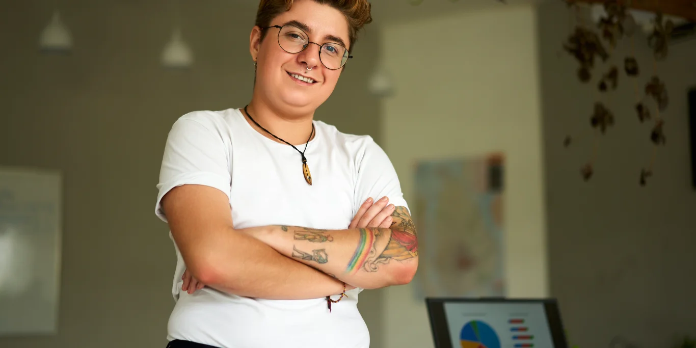 Confident transgender professional stands in modern office